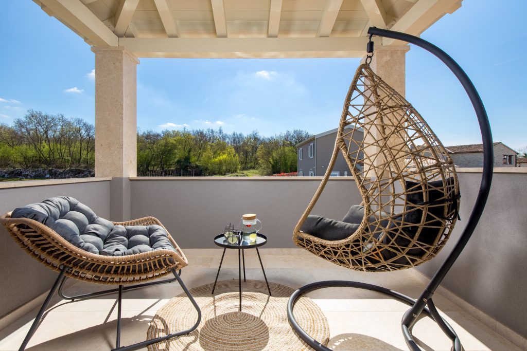 Balcony lounge with hanging chair and countryside view