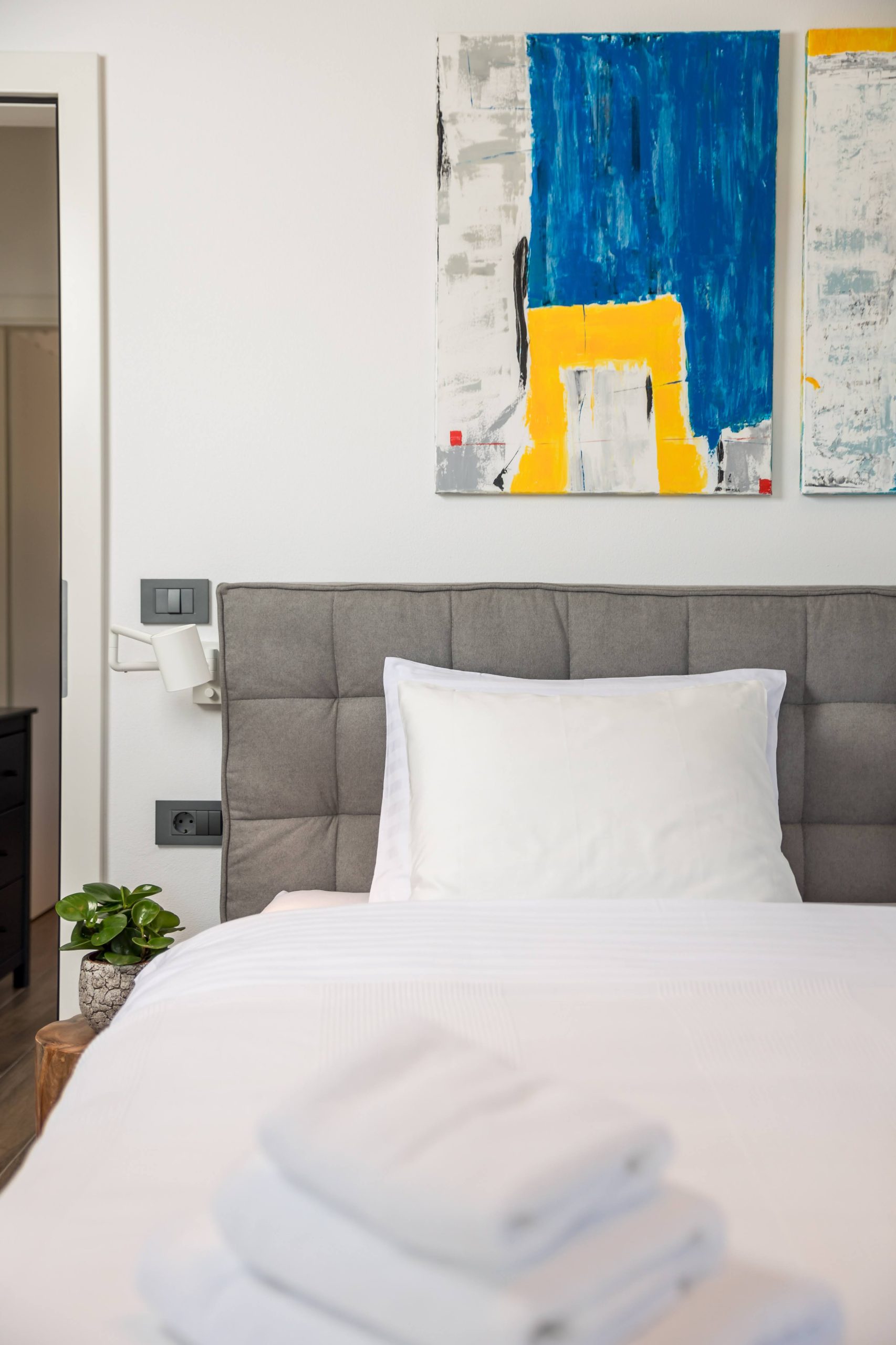 Bedroom headboard detail with colorful wall art