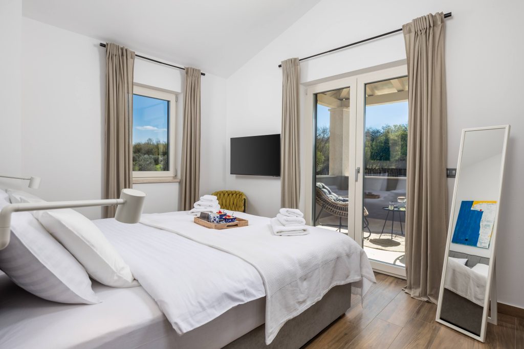 Bedroom with standing mirror and balcony view