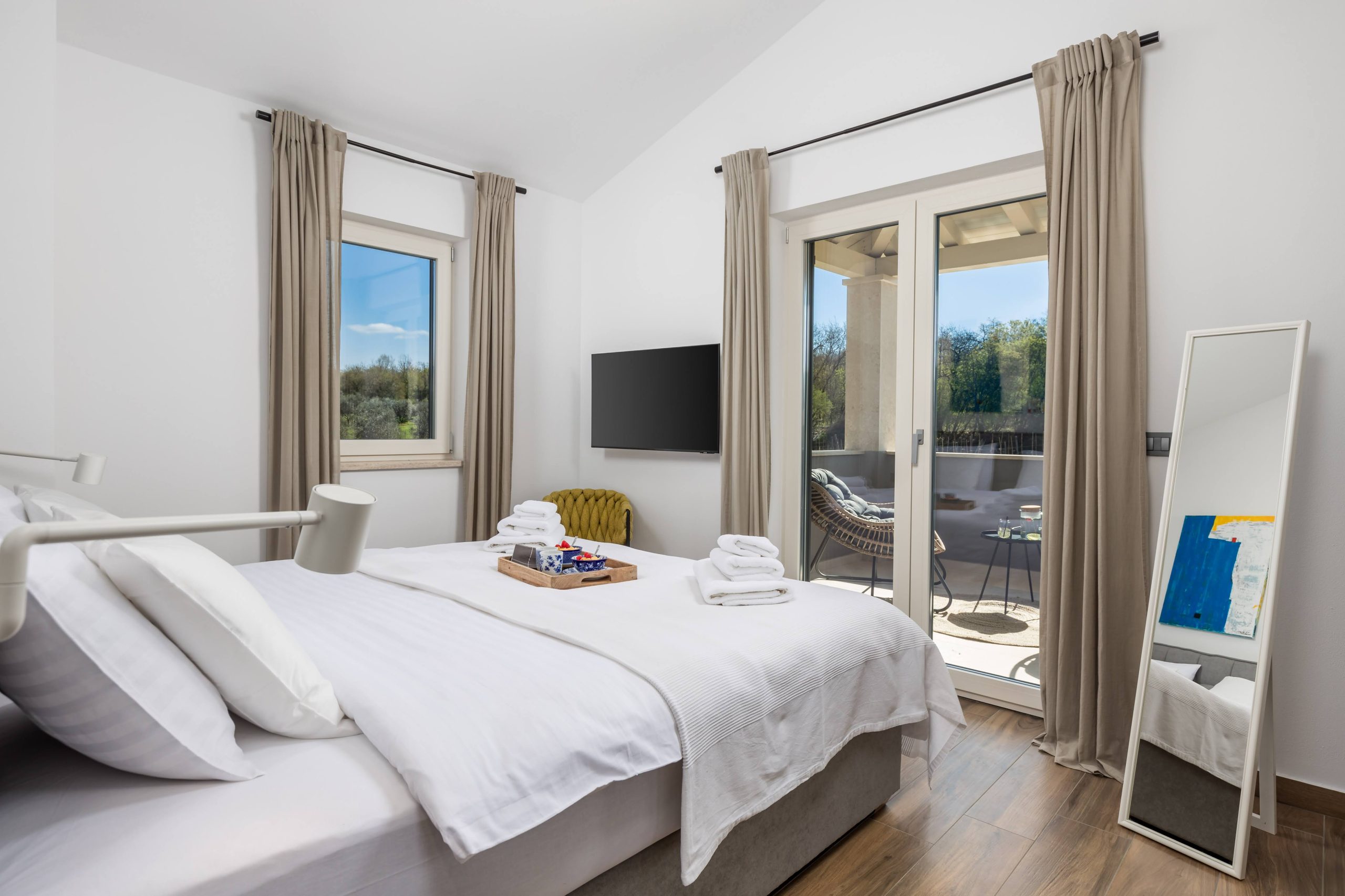 Bedroom with standing mirror and balcony view