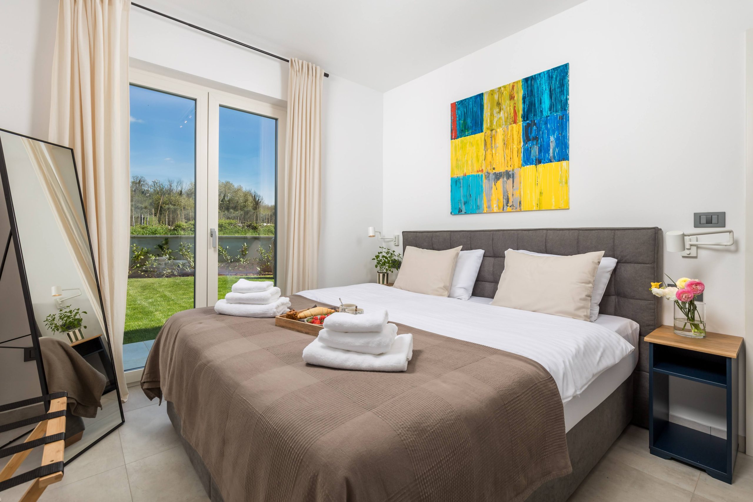 Bedroom with standing mirror and garden terrace view