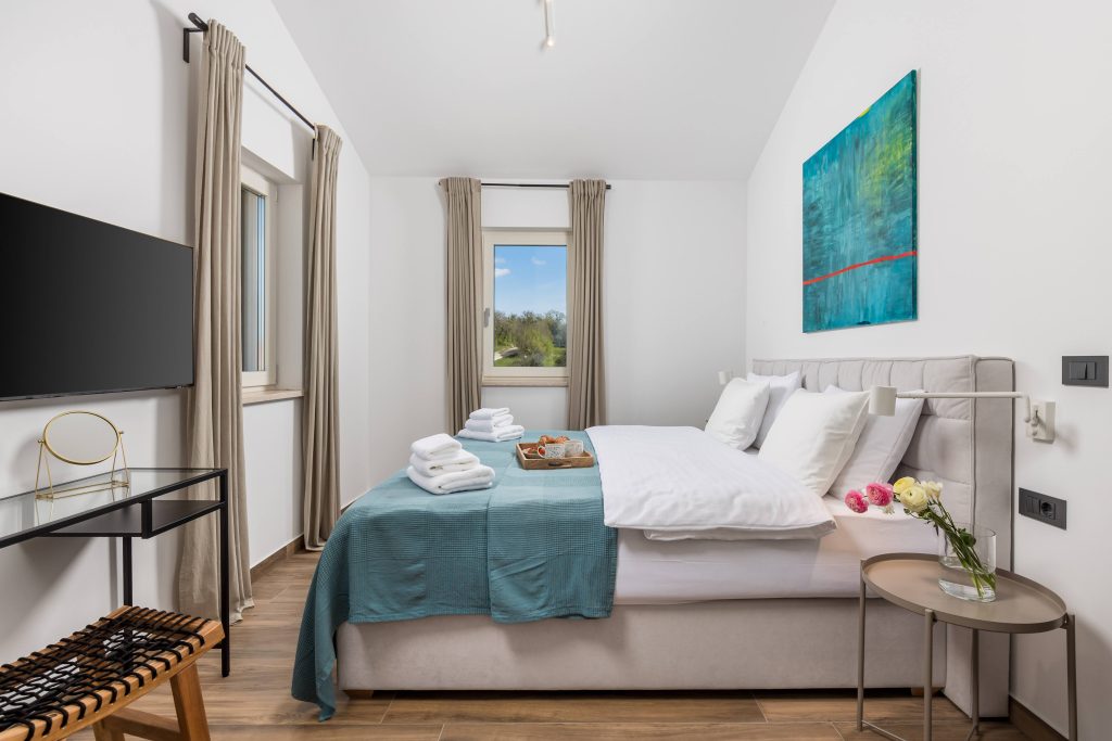 Bedroom with turquoise artwork and window view