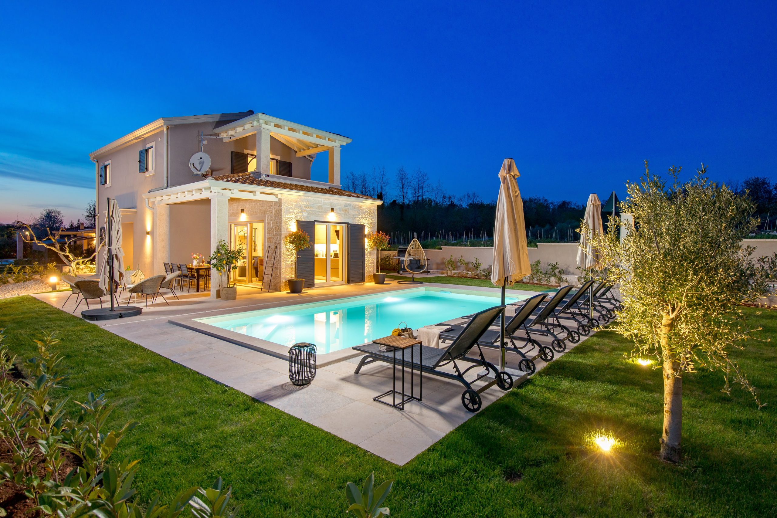 Villa and private pool lit up at blue hour