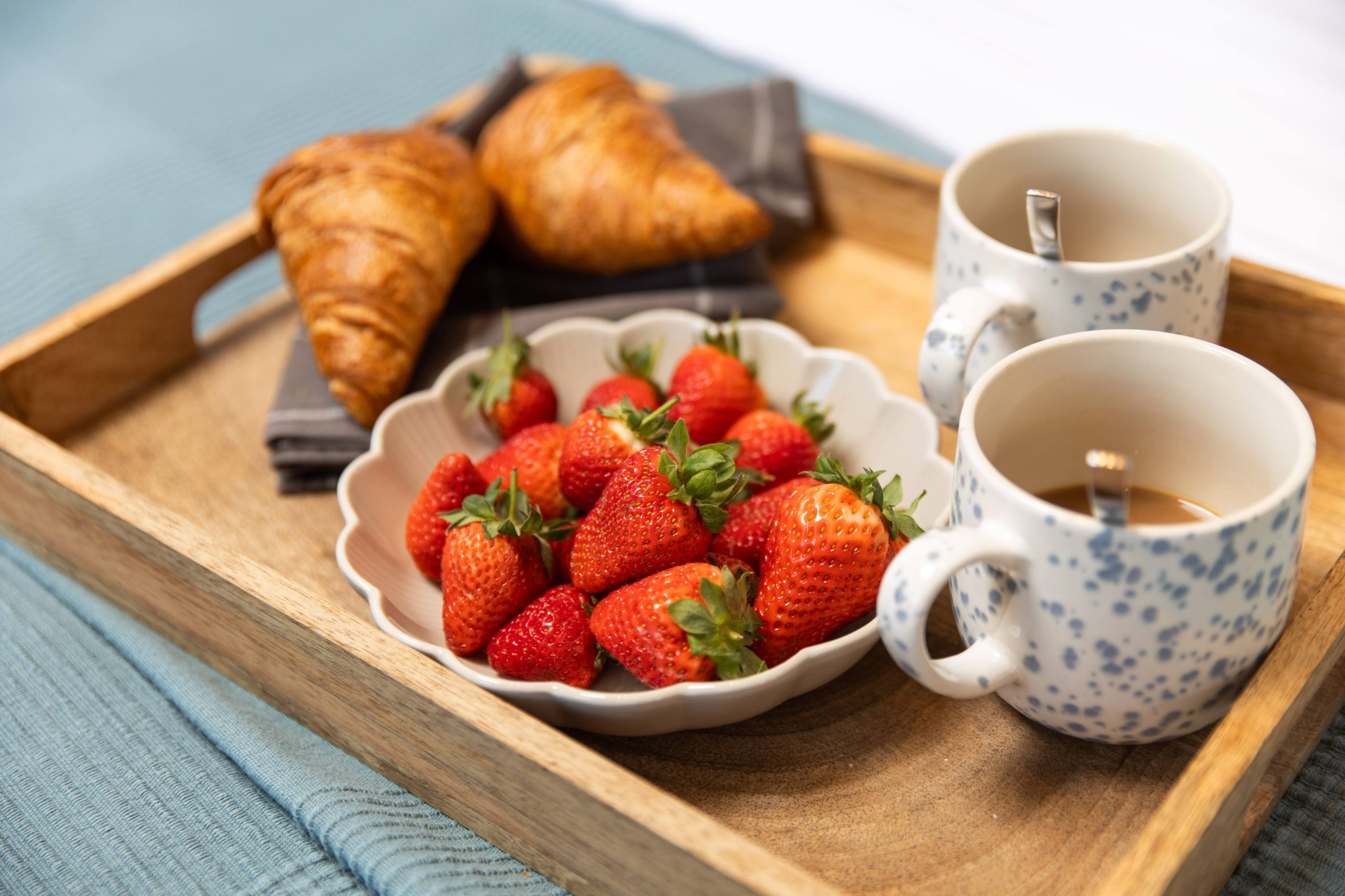 Breakfast in bed with croissants and fresh strawberries