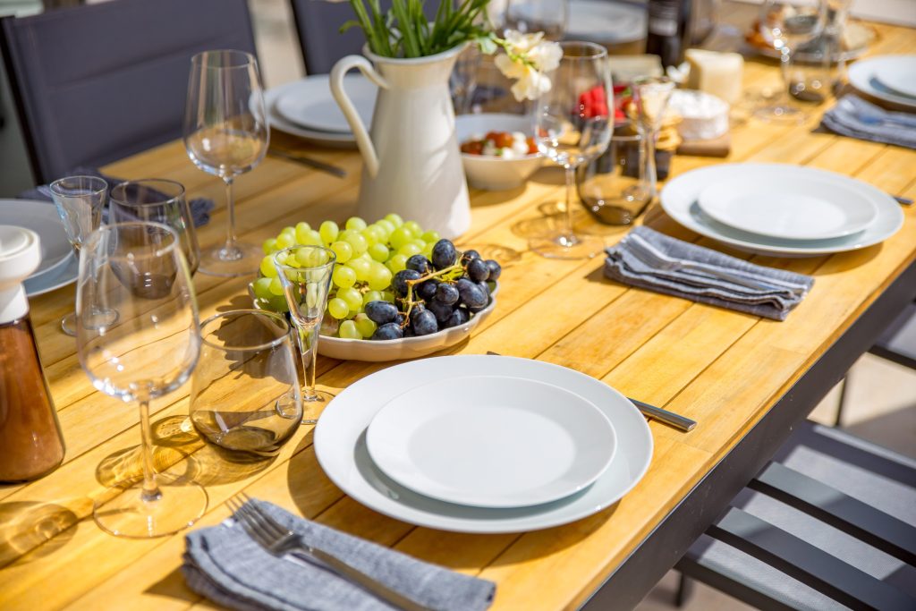 Outdoor dining table set with grapes and wine glasses