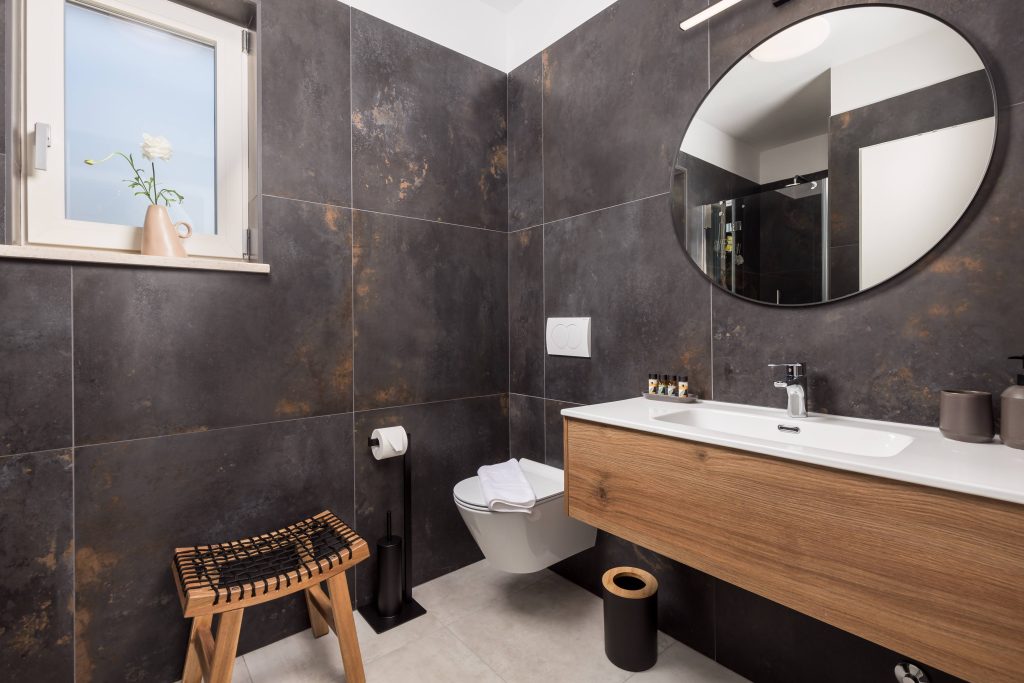 Ensuite bathroom with dark tile and wooden vanity
