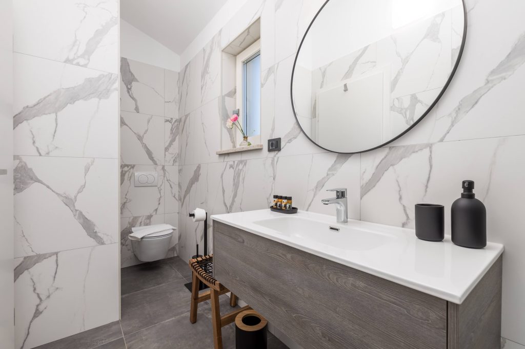 Ensuite bathroom with marble tiles and wall-hung toilet