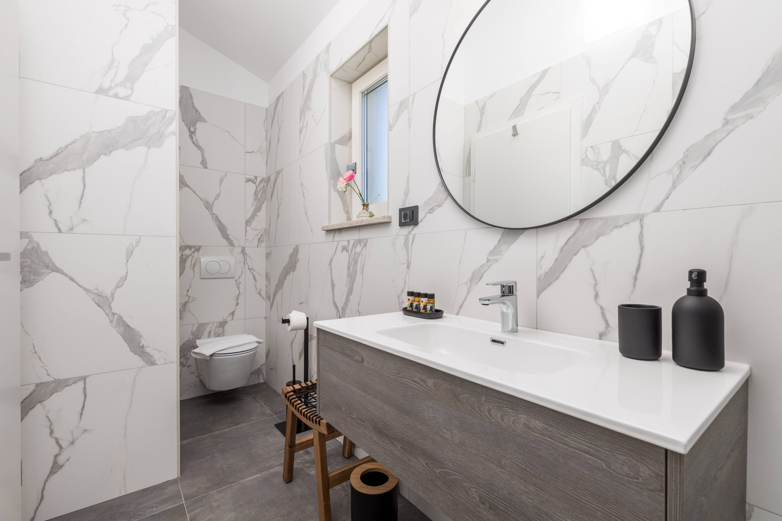 Ensuite bathroom with marble tiles and wall-hung toilet