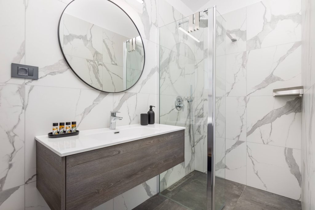 Ensuite bathroom with walk-in shower and round mirror