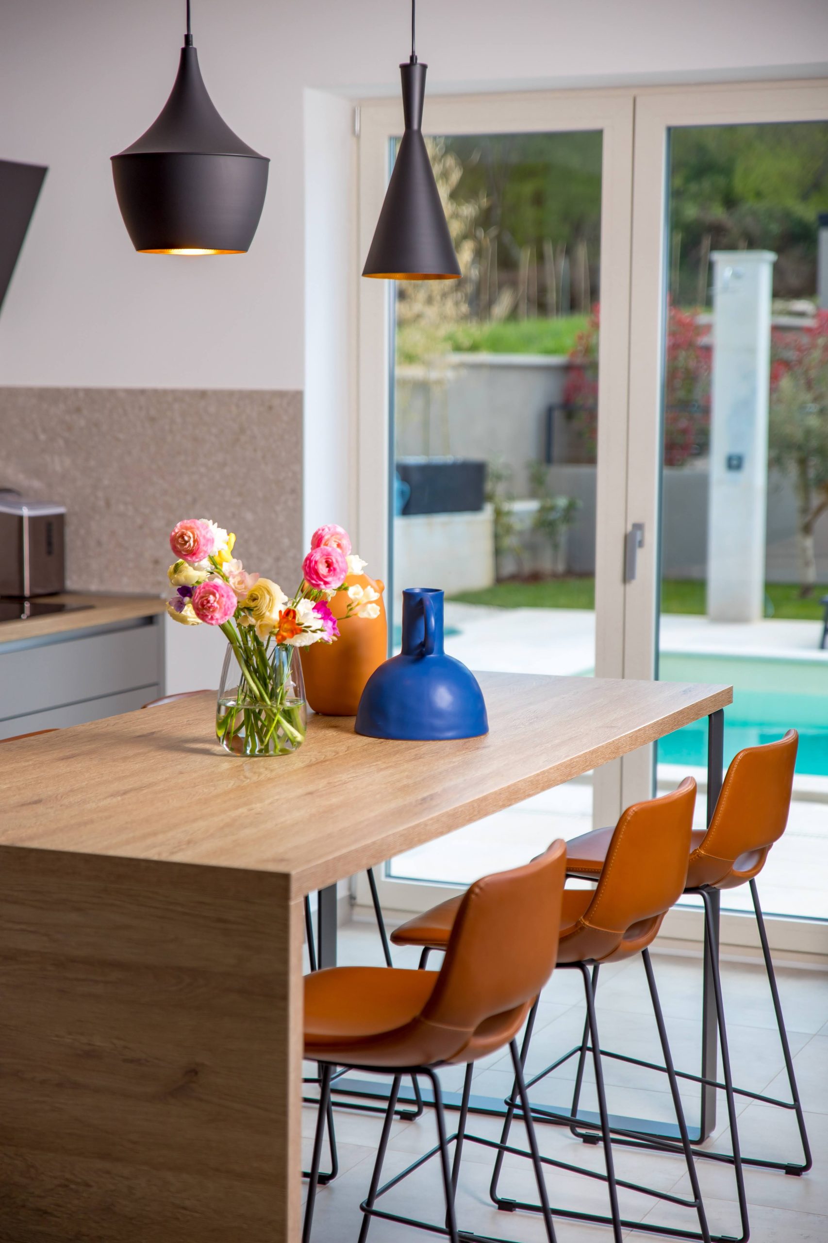 Kitchen island with fresh flowers and pool view