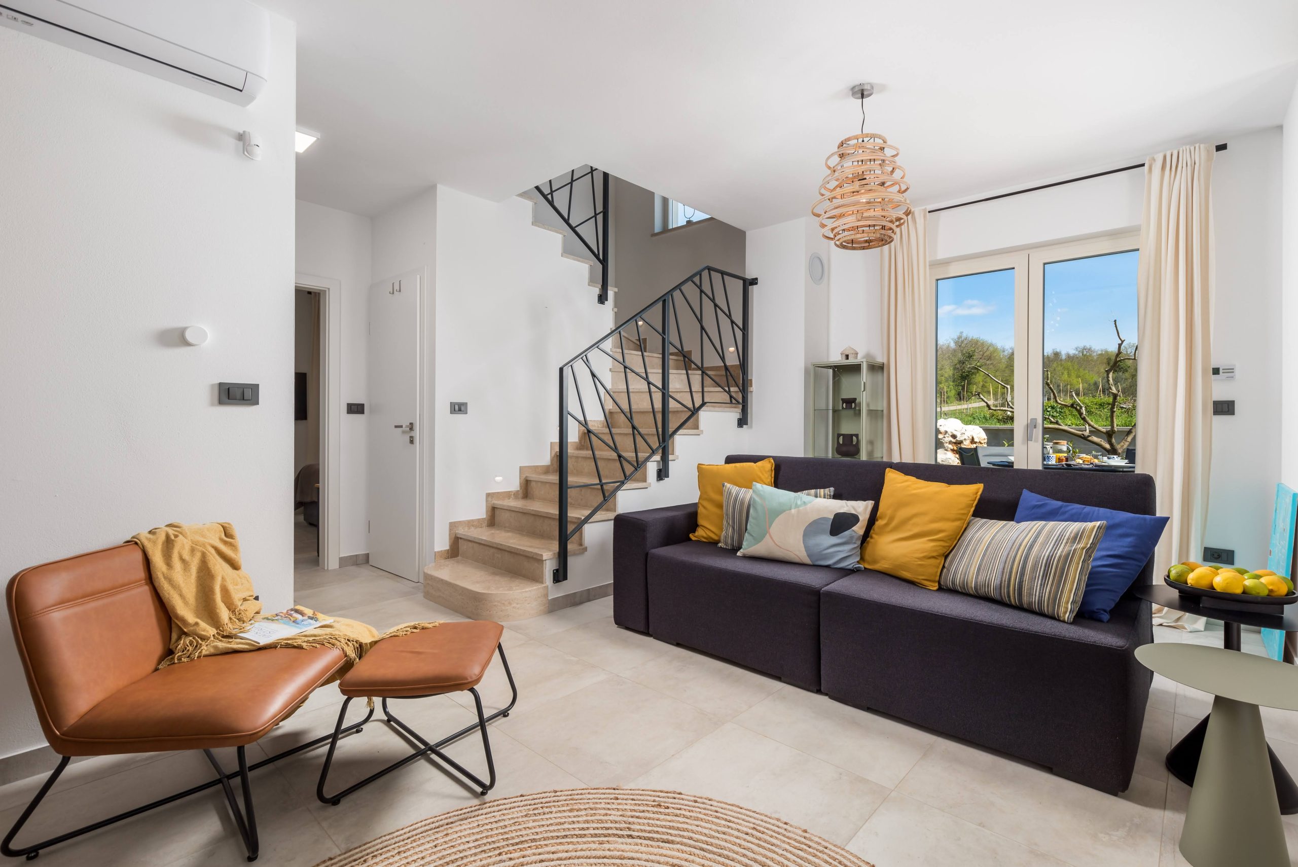 Living room sofa with staircase and garden view