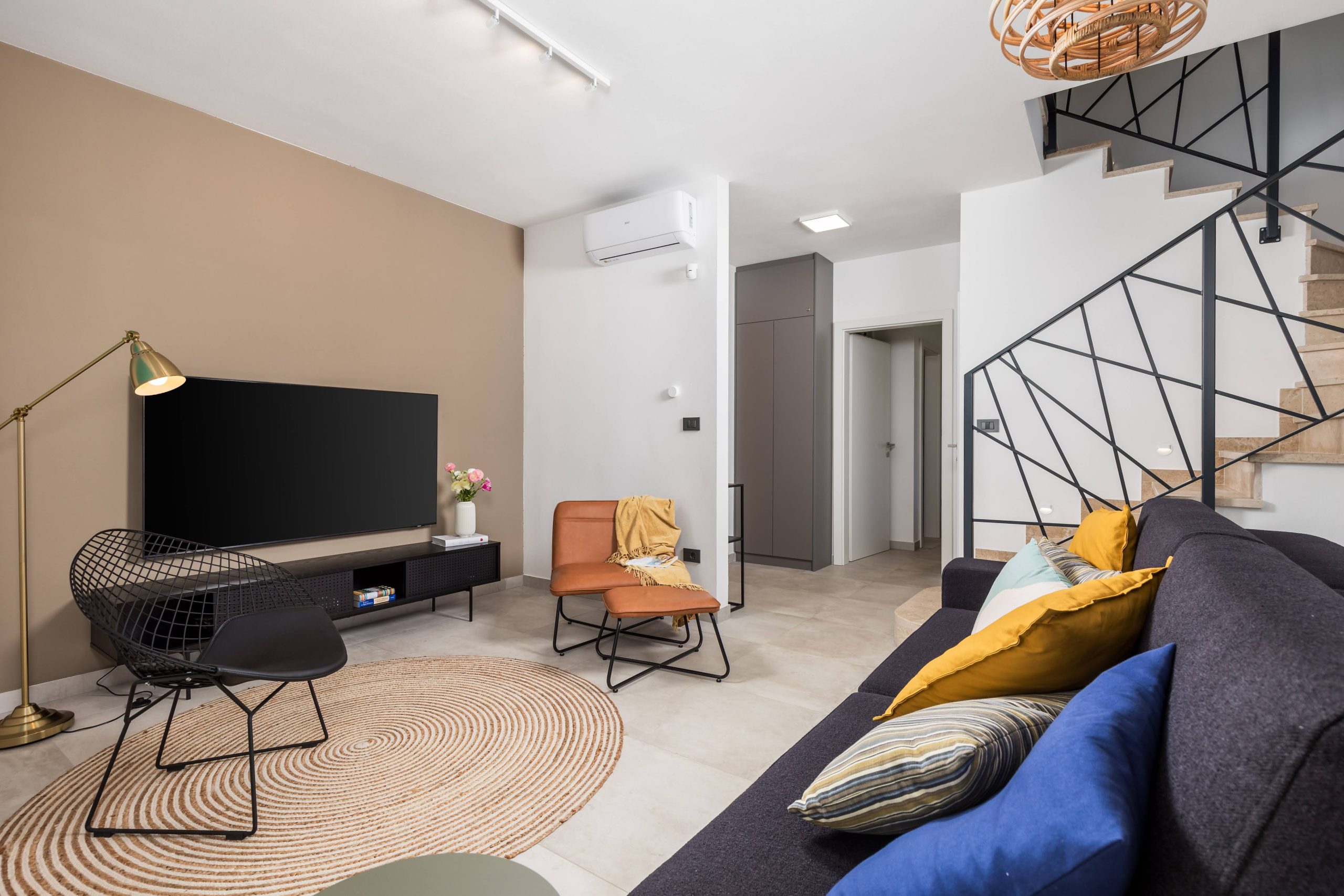Living room with flat-screen TV and staircase