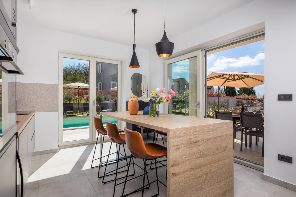 Open-plan kitchen and dining area with pool view