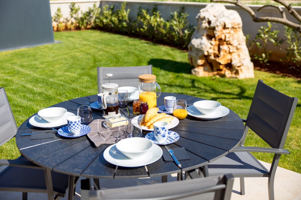 Outdoor breakfast table set with croissants and coffee