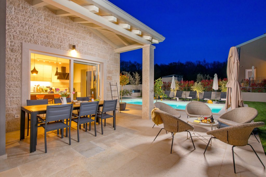 Outdoor dining table and lounge seating at twilight