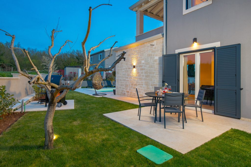 Outdoor dining terrace set for dinner at twilight