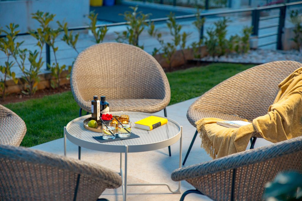 Outdoor lounge chairs with evening drinks and a book