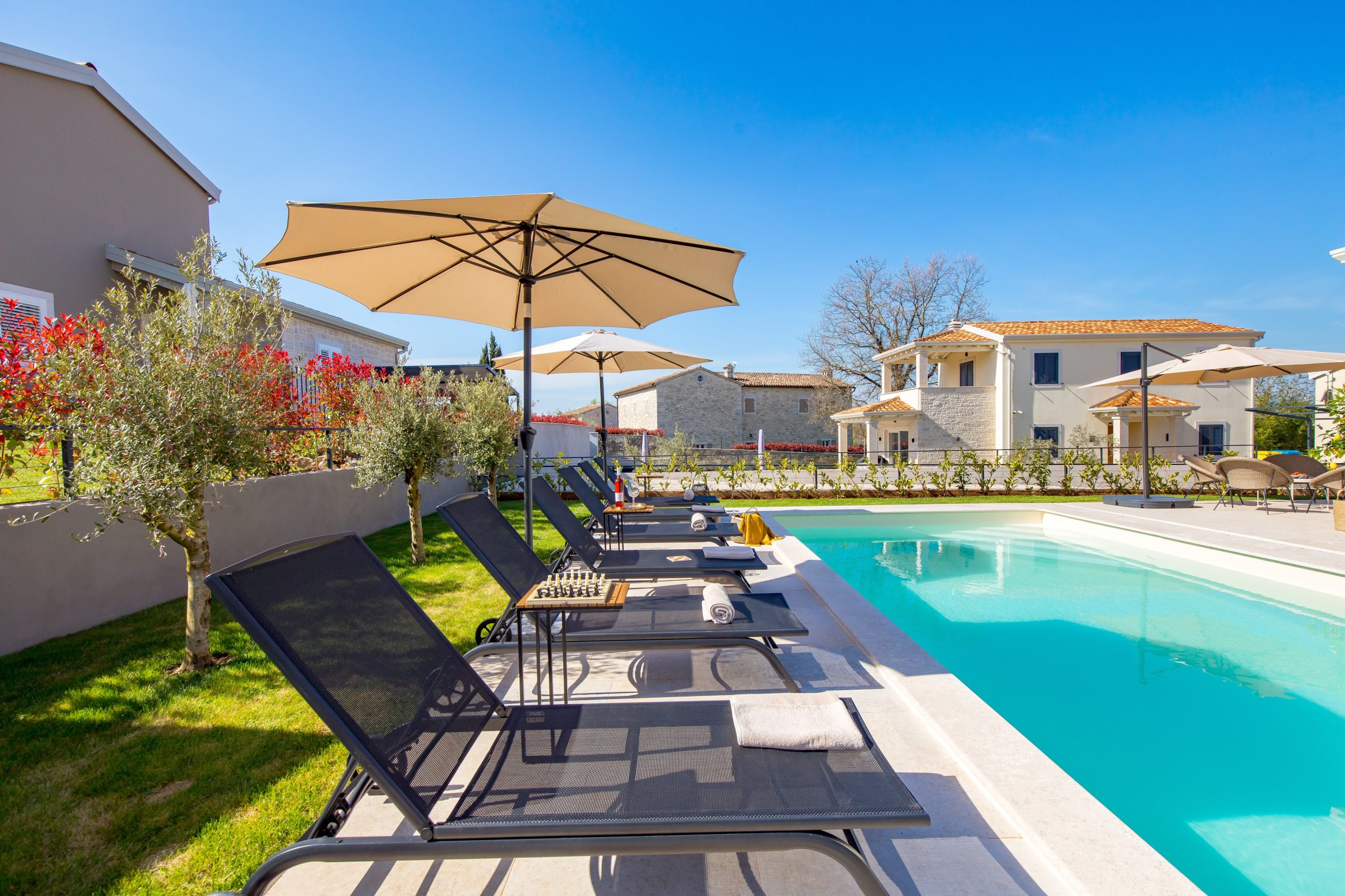 Wide view of the pool, garden and sun loungers