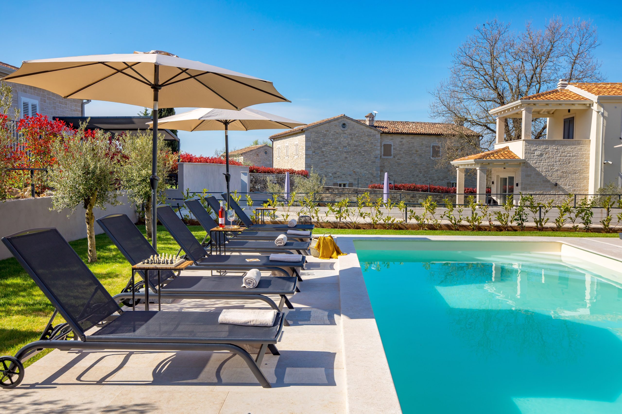Private pool with sun loungers and poolside pavilion view