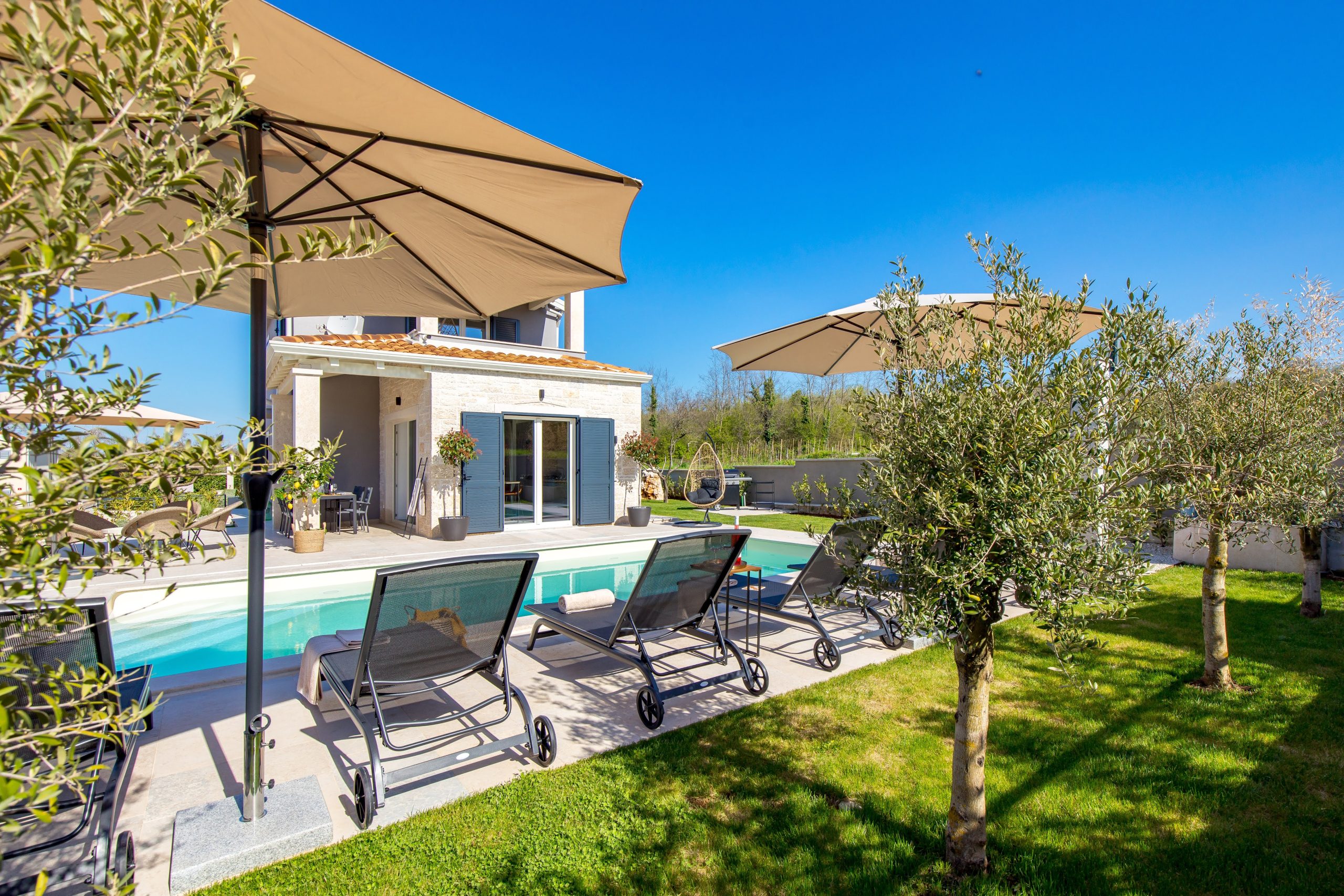 Villa facade overlooking the private pool and olive trees