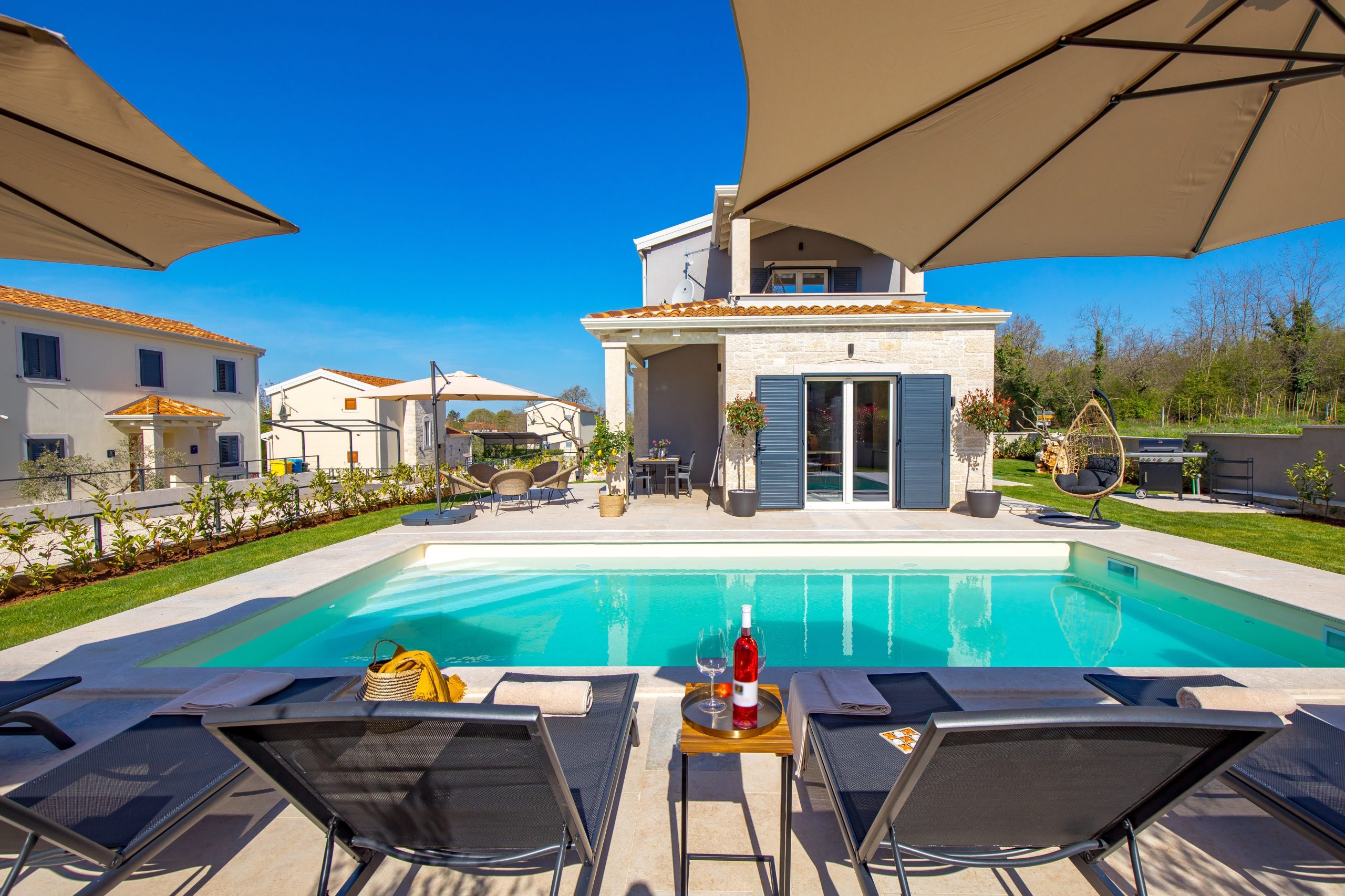 Wine glasses by the pool overlooking the villa terrace