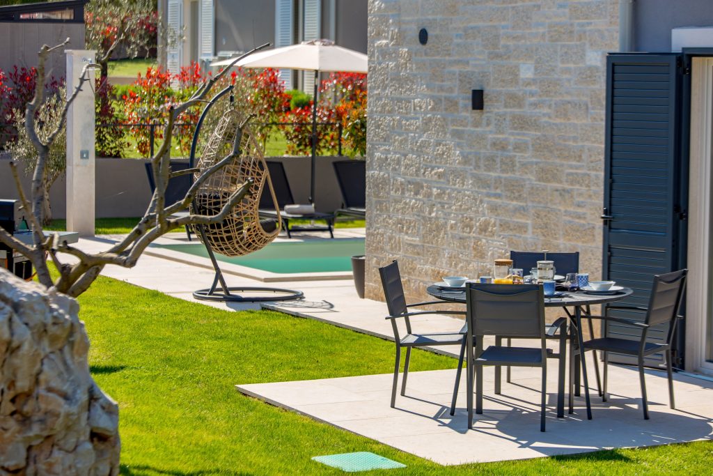Round outdoor dining table with garden and pool view