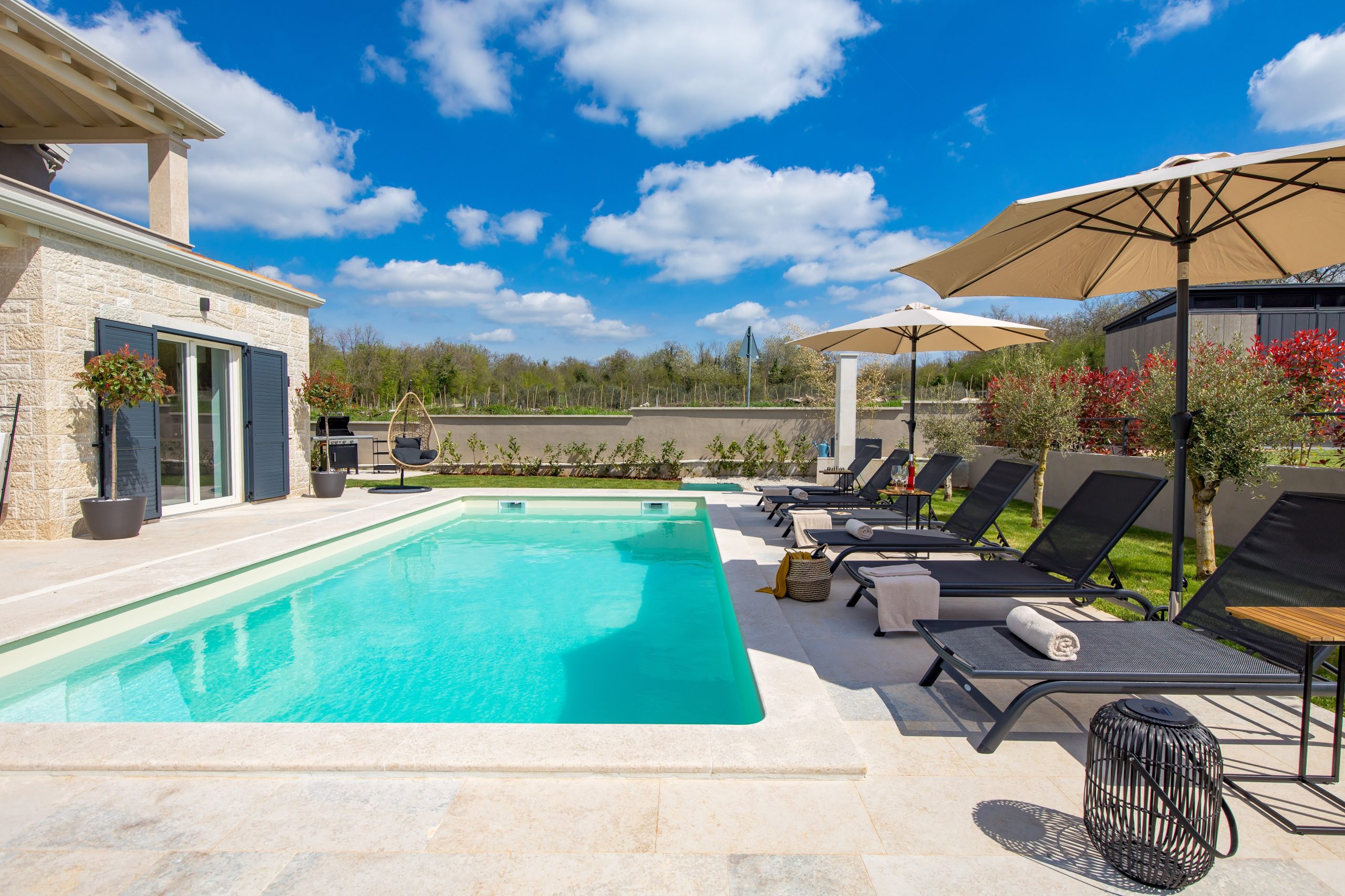 Sun loungers along the garden edge near the pool